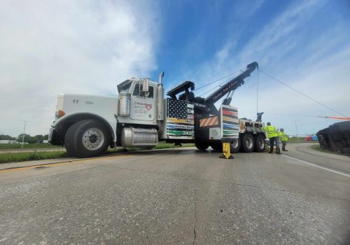 A large wrecker providing Towing Service near Champaign IL for a toppled semi-truck