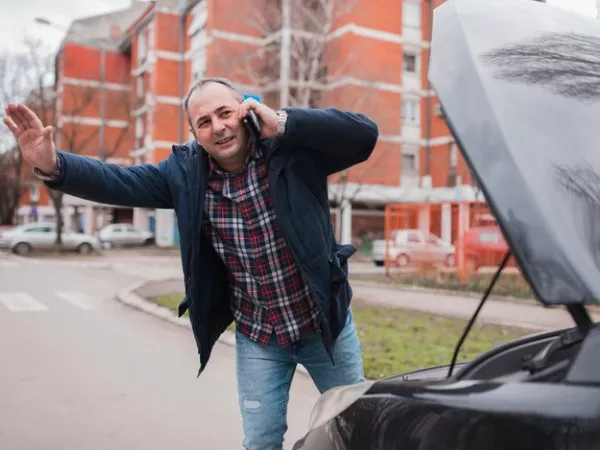 Person waving down tow truck