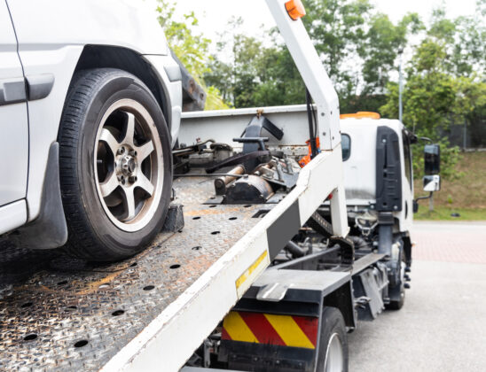 Cable attached to broken down car being pulled onto flatbed tow truck in Champaign IL